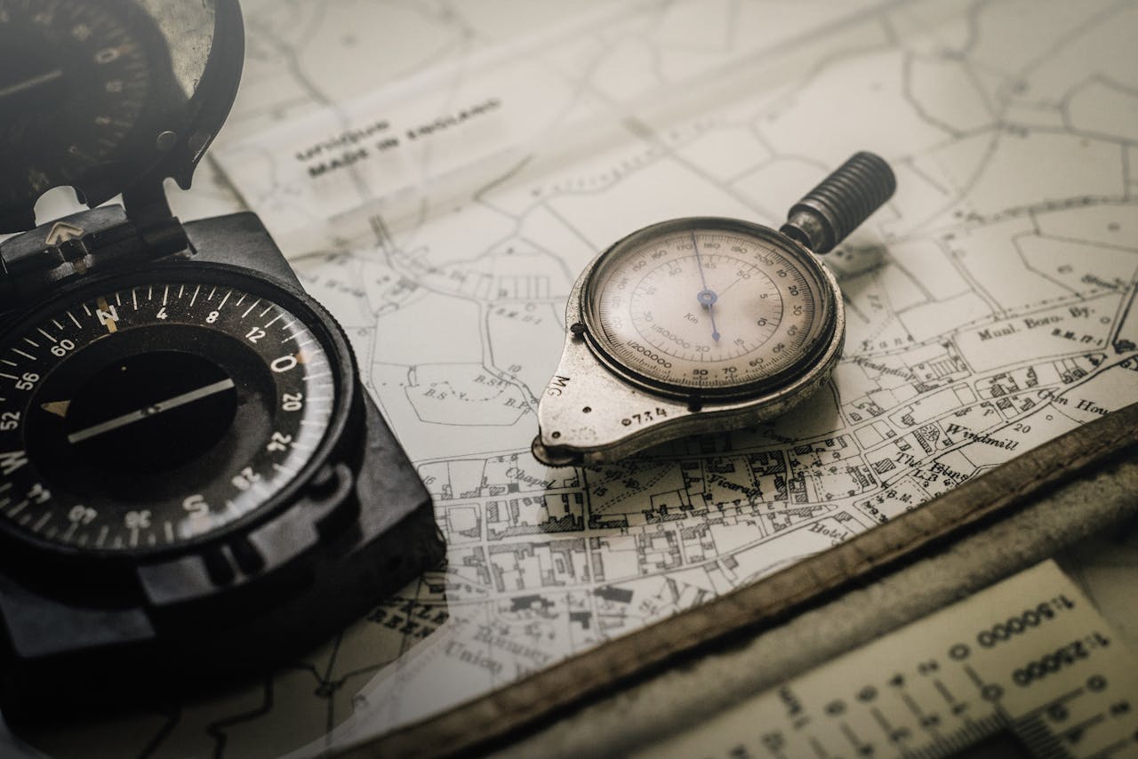 services-01 A vintage compass and navigation instrument on an old map, showcasing precision tools for exploration.