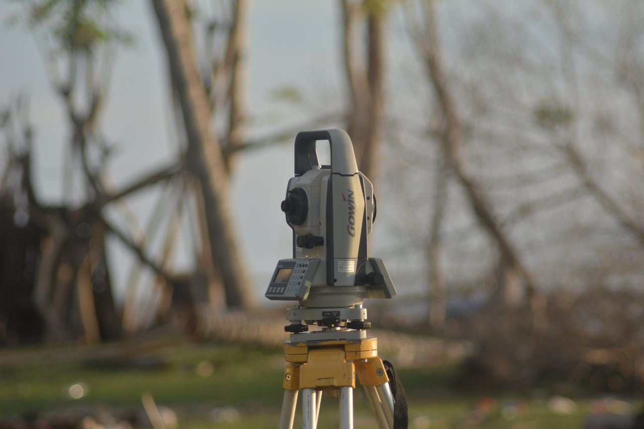 team-01 A precise total station used for geodetic surveying at a construction site with a natural background.