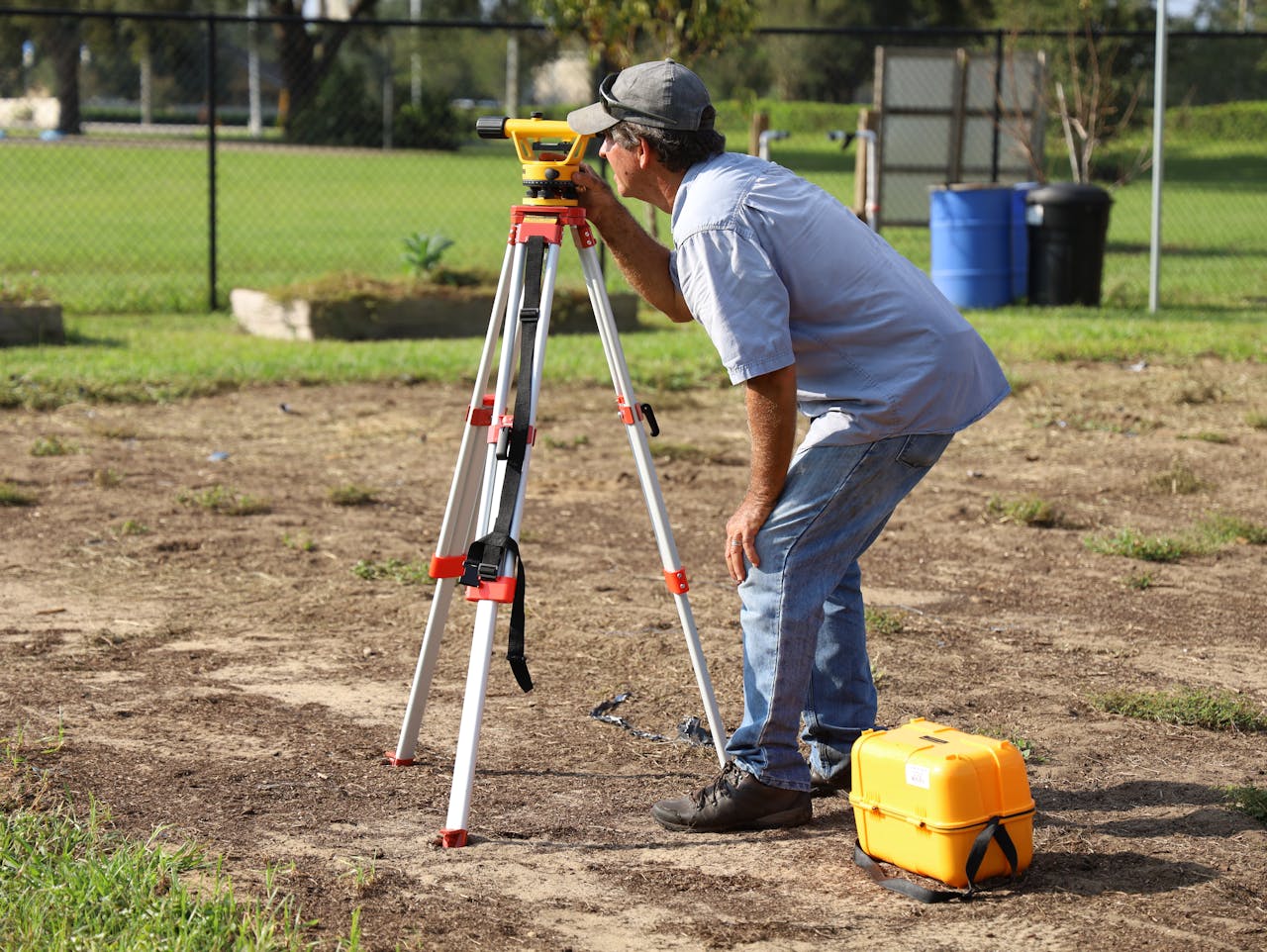 services-01 A land surveyor at work using equipment on a field in Tavares, Florida.